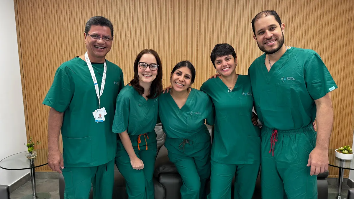Cinco profesionales del Hospital Paitilla en ropa quirúrgica verde, sonriendo juntos tras una jornada de grabación