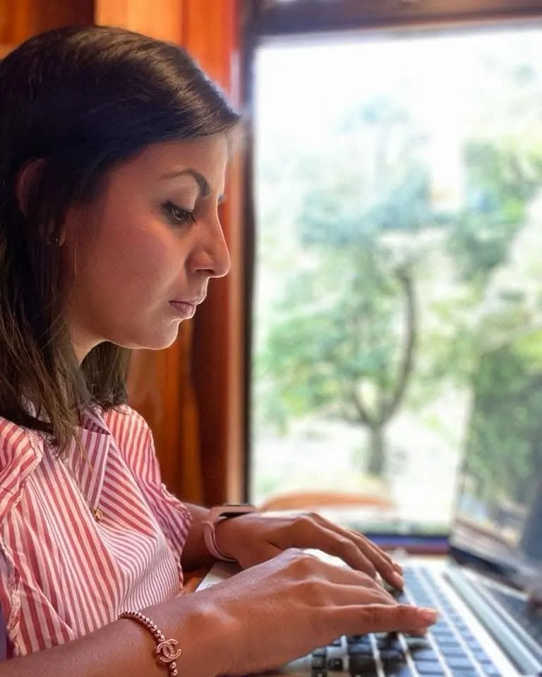 Socia de Nayita trabajando en el portátil junto a una ventana