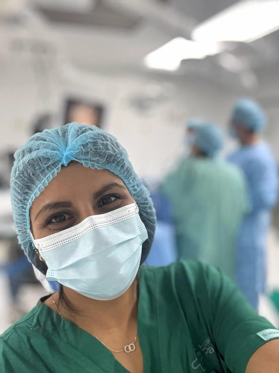 Nuestra fotógrafa en primer plano dentro de un quirófano, con el equipo médico trabajando detrás